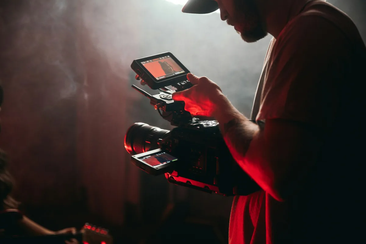 Videographer filming with professional cinema camera on set